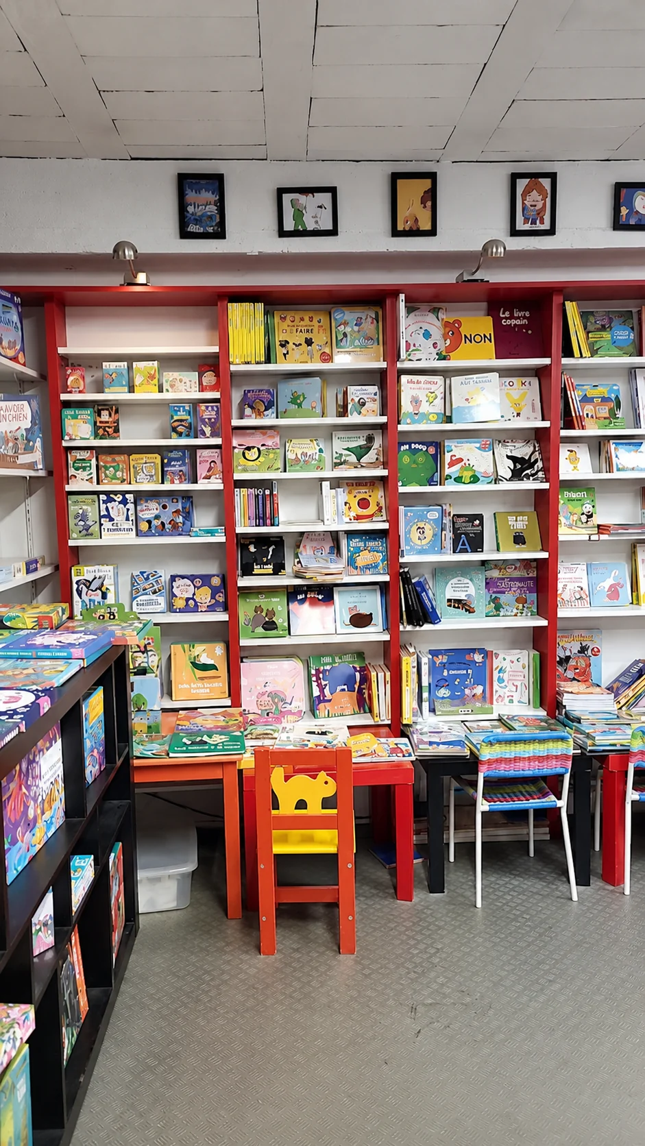 L'espace jeunesse avec ses albums présentés de face, ses petites tables et ses chaises adaptées aux enfants